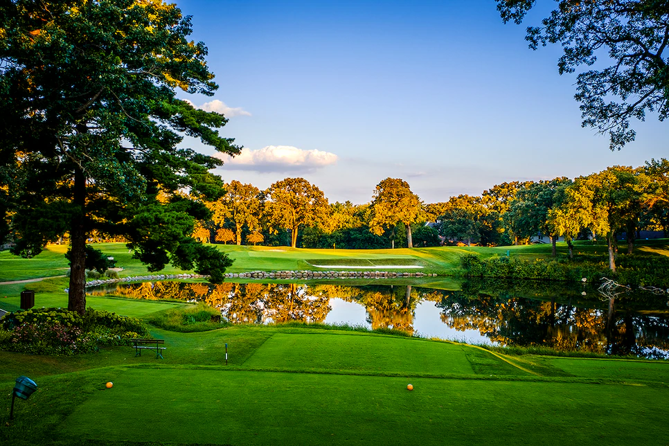 Golf course at golden hour with a pond fronting the green